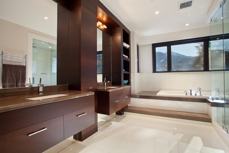 Bathroom with Wooden Vanity and White Tub near Glass Shower Space