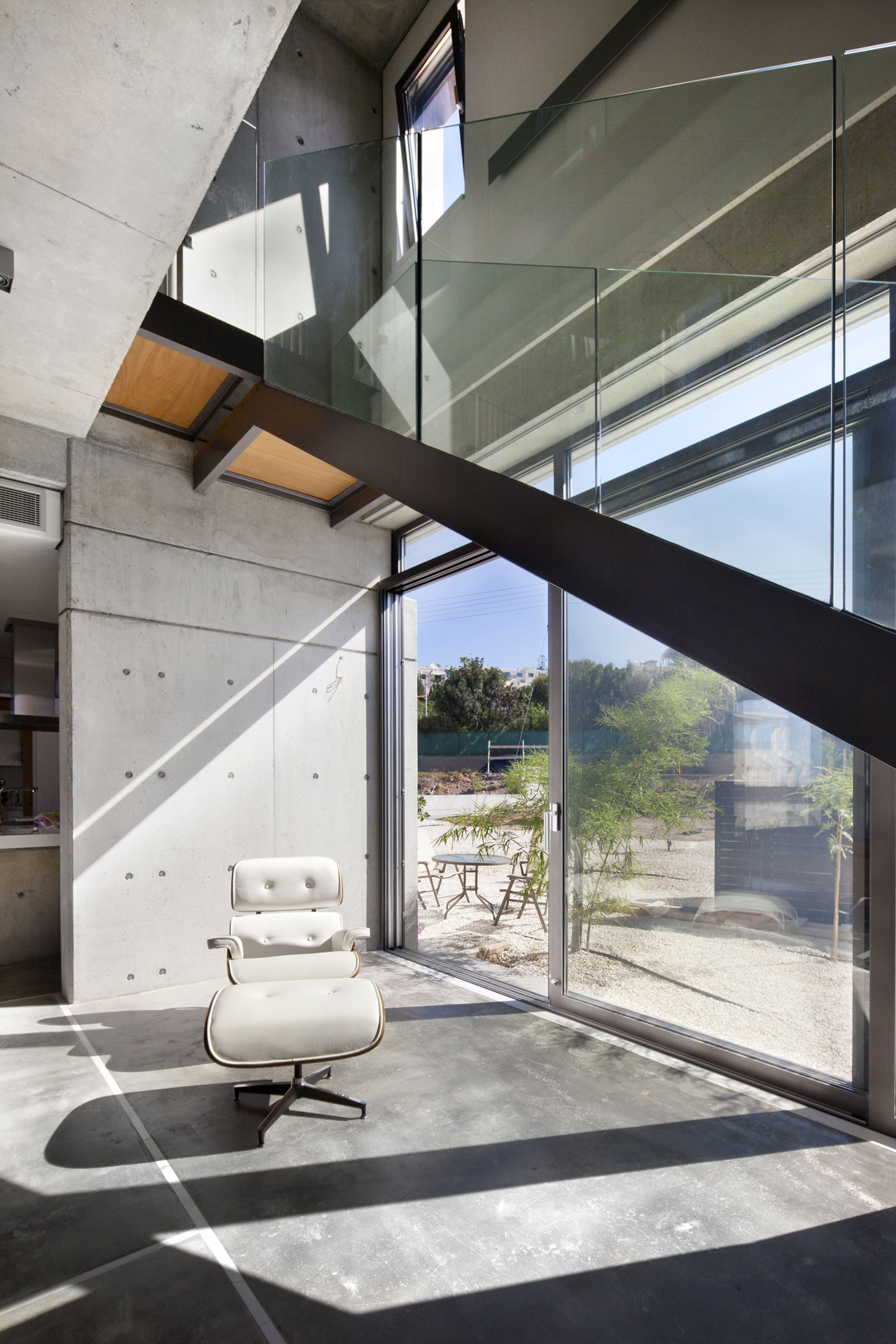 Andri & Yiorgos Residence - White Chair Grey Concrete Floor Also Windows Which Are Made From Glass Panels