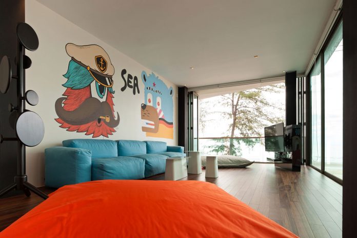 Long Blue Sofa Also White Tables Near Fun Wall Art