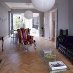 Black Sofas Added Near Colorful Single Lounger On Wooden Board Flooring
