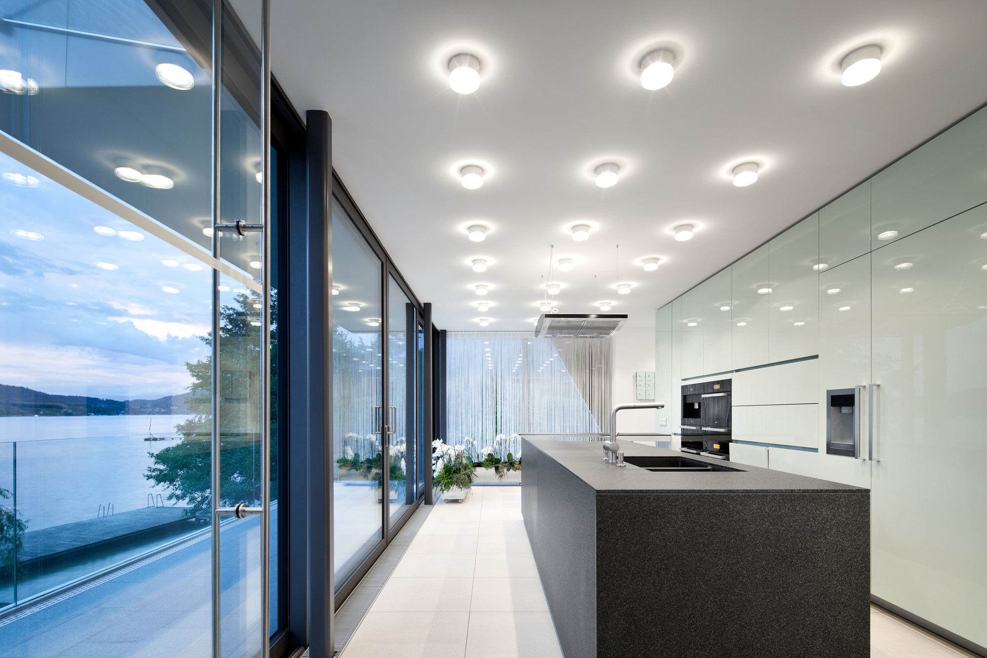 Ceiling Lamps Illuminate Glossy Kitchen Cabinet Along With Grenite Island