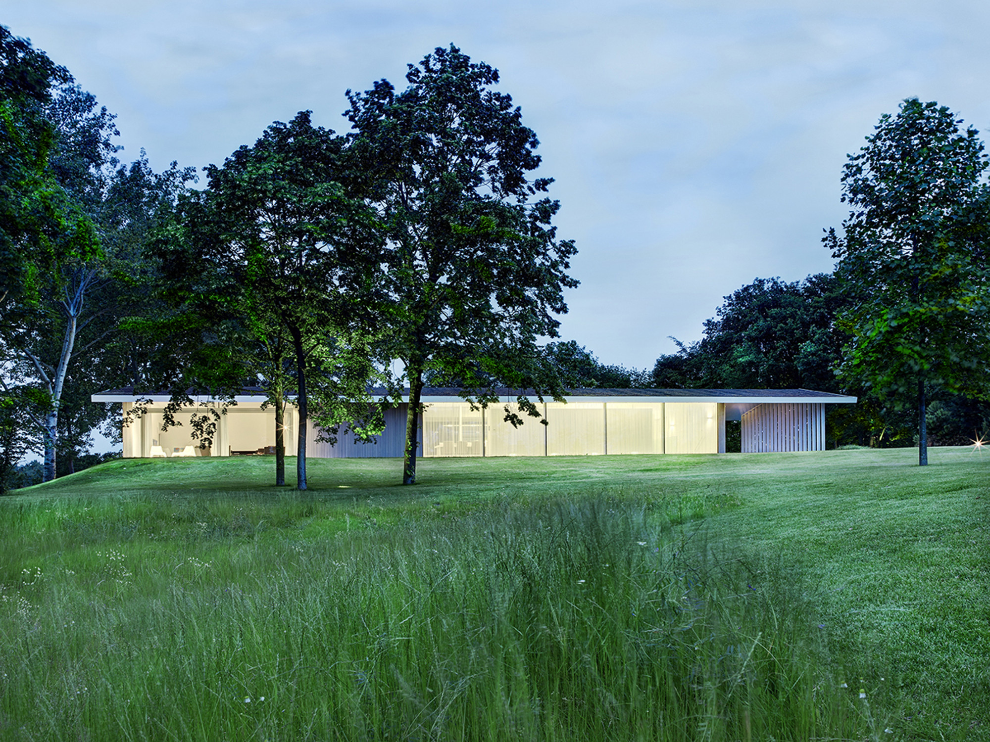 House Near Clear Colored Outer Wall Along With Bright Yellow Lighting Inside