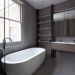 Oval Bathtub Added Near Metallic Water Faucet On Floor Near Bay Window