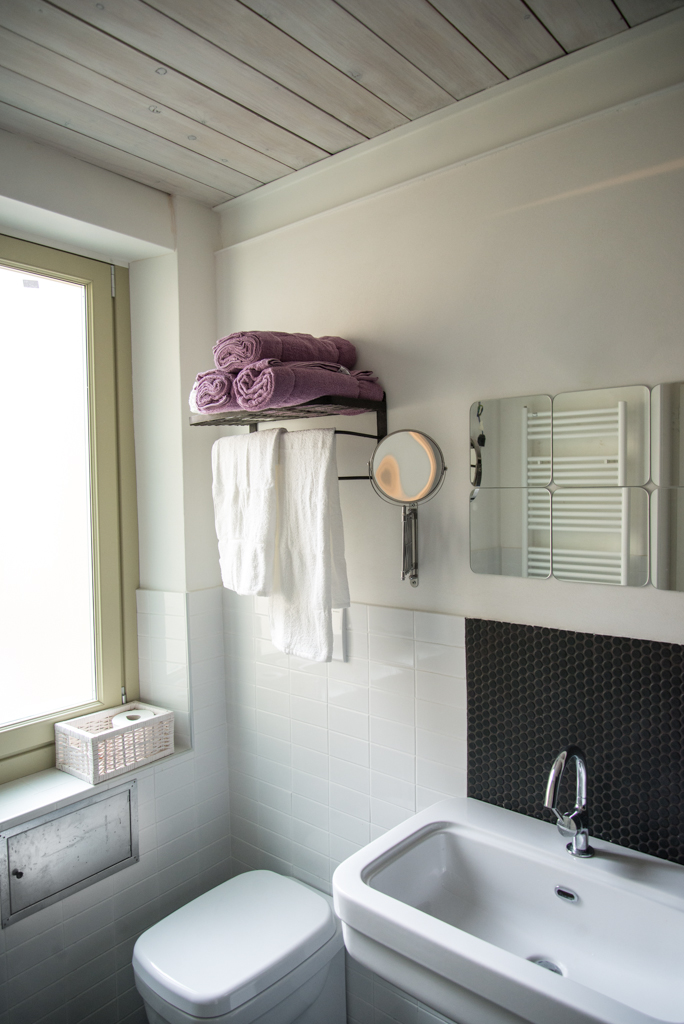 Via delle Orfane by CON3STUDIO - Ceramic Bathtub Added Near Metallic Faucet Also Glass Window On Wall