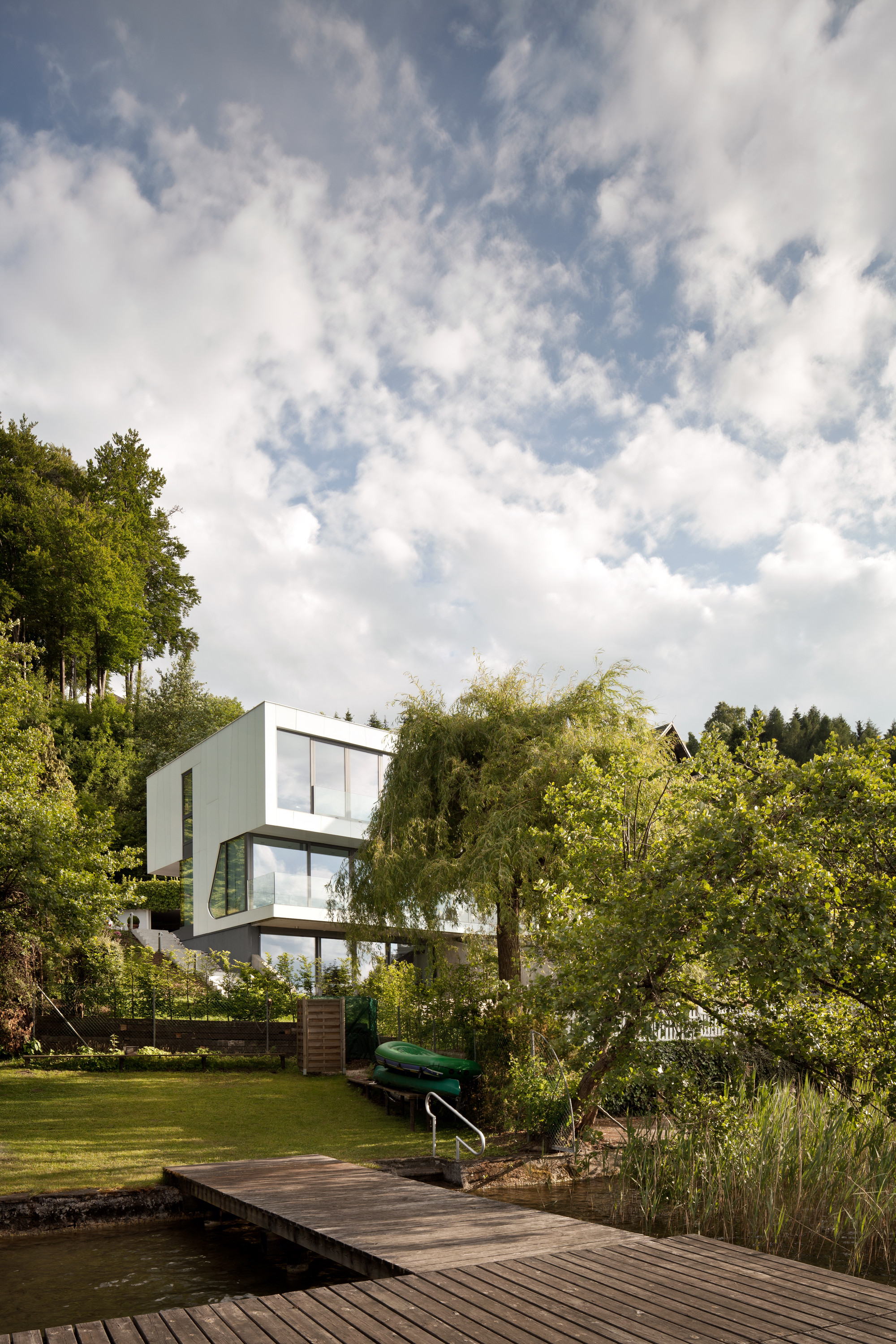 Wooden Deck Along With Water Feature Surrounded Green As Well As Lush Vegetations